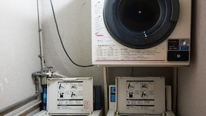 A compact laundry area with two front-loading washing machines and a dryer, connected to a wall-mounted vent. - Nishijin-IVY Bunk bed twin (Kyoto)