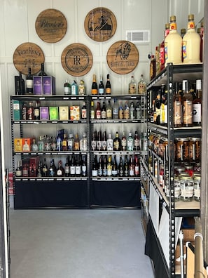 Uma loja de bebidas com prateleiras repletas de garrafas e caixas de álcool.