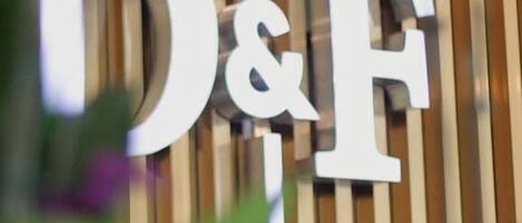 A sign with the letters "D&F" on a wooden background.