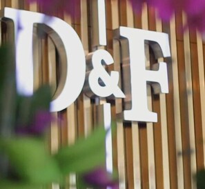 A sign with the letters "D&F" on a wooden background.