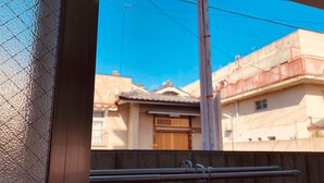 A view of a residential area with traditional Japanese architecture, including a wooden gate and a tiled roof. - Nishijin-IVY 5 beds (Kyoto)