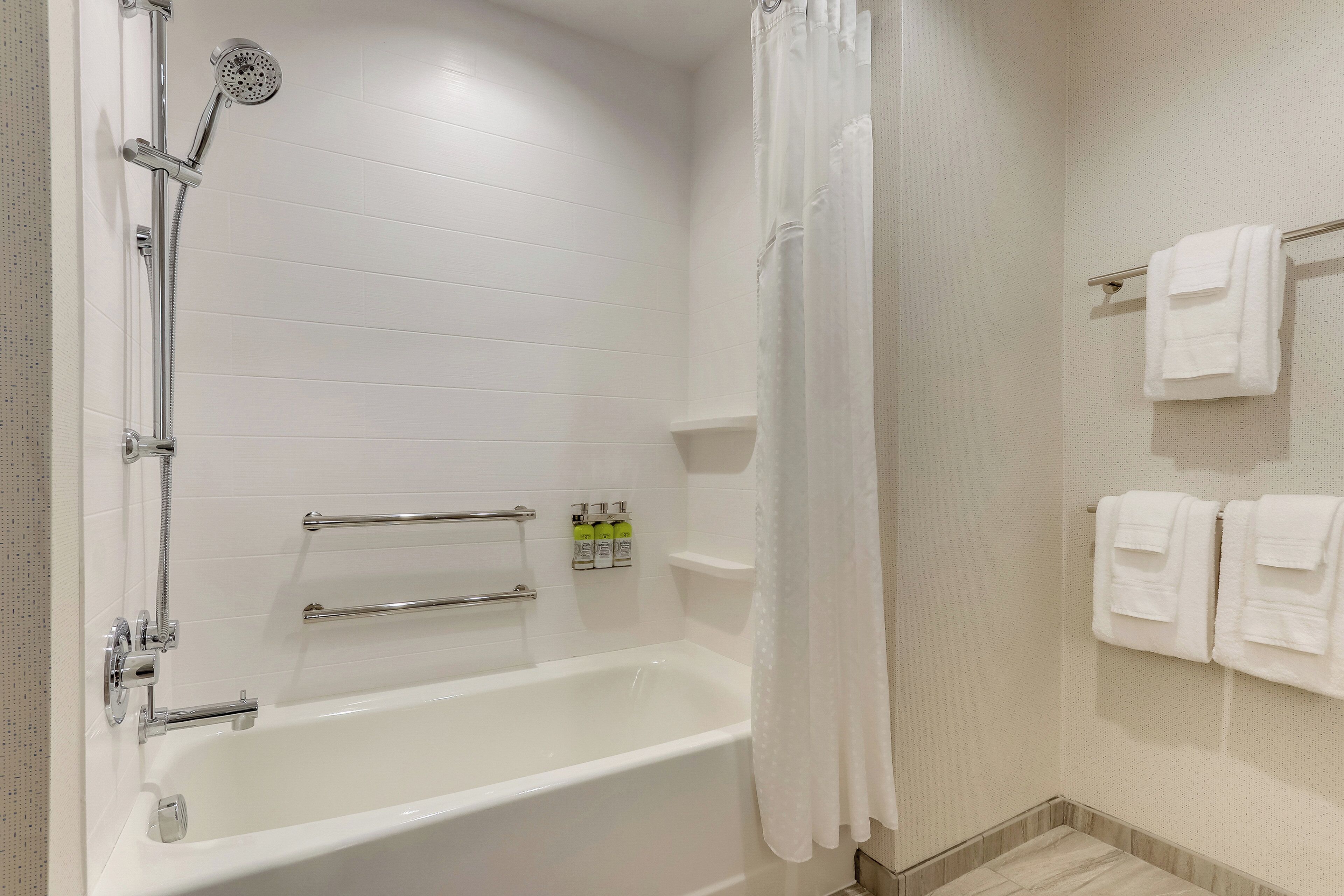 A bathroom with a bathtub, shower, and towel rack.
