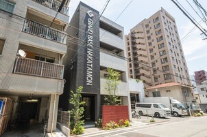 Un edificio de varios pisos con un cartel llamativo que dice "GRAND BASE HAKATAMON".