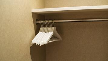 A white towel rack with multiple towels hanging on it, mounted on a beige wall.