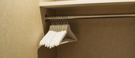 A white towel rack with multiple towels hanging on it, mounted on a beige wall.