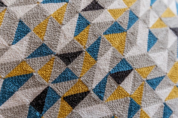 A close-up of a knitted fabric with a geometric pattern.