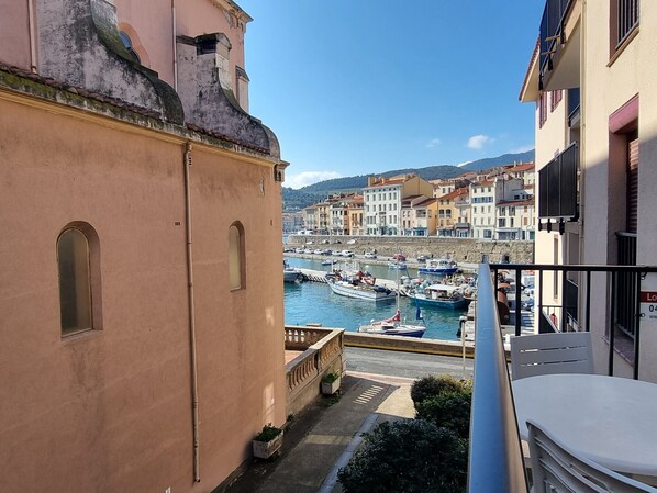 A balcony overlooking a harbor with boats, historic buildings, and a clear sky. - Port-Vendres apartment, harbor view, parking & WIFI (Port-Vendres)