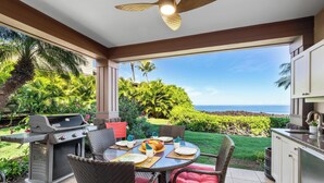 Une terrasse extérieure équipée d’un barbecue, d’une table à manger, de chaises et offrant une vue sur l’océan.