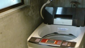 A compact, white, front-loading washing machine with a control panel and a water inlet hose. - Ichijyo-IVY Semi double (Kyoto)