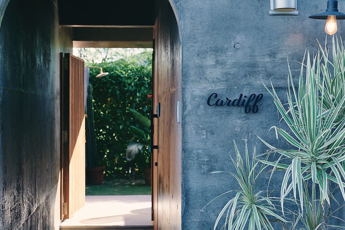 A doorway leading to a garden with a sign reading "Cardiff".