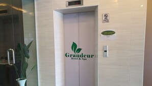 A hotel entrance with a 'Grandeur Hotel & Spa' sign, a 'No Pets Allowed' sign, and a contact number for inquiries. - Grandeur Hotel and Spa (Malacca City)