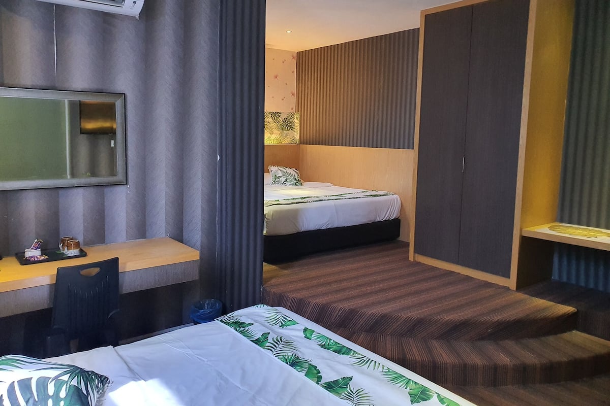Una habitación de hotel moderna con cama, escritorio, armario y aire acondicionado.