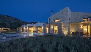 A modern house with a swimming pool, stone walls, and a mountain backdrop. - Alessia Luxury Villas (Lefkada)