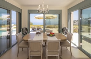 A dining area with a large table, chairs, and a view of the outdoors.