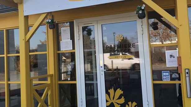 A hotel entrance with a yellow facade, glass doors, and a sign reading "Premiere Classe Hotels". - Premiere Classe Rennes Ouest - Le Rheu (Le Rheu)