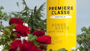 A yellow sign with the text "PREMIERE CLASSE HOTELS" and translations in multiple languages. - Premiere Classe Rennes Ouest - Le Rheu (Le Rheu)