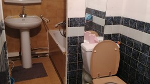 Une salle de bain avec un lavabo, des toilettes et une baignoire.