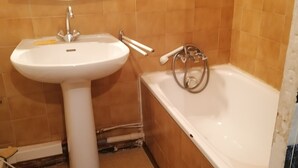 Une salle de bain avec un lavabo, une baignoire et une douche.