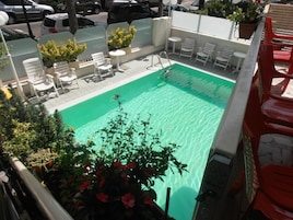 Una piscina al aire libre de temporada, sombrillas, tumbonas