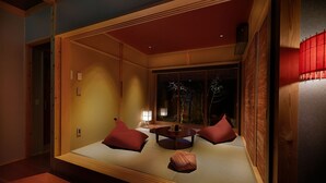 Ein traditioneller japanischer Raum mit Tatami-Böden, einem niedrigen Tisch und Kissen.