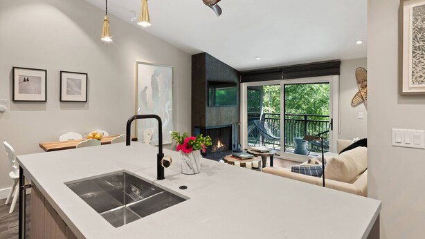 A modern kitchen with a large island, pendant lighting, and a fireplace. - Remodeled Aspen Gem! 1 Block to Aspen Mtn, Balcony with Views, W/D, Parking & Walk to Town (Aspen)
