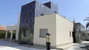 Un bâtiment moderne doté d’un toit plat, d’une grande fenêtre et d’une porte.