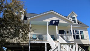 A two-story house with a balcony and a flag.
