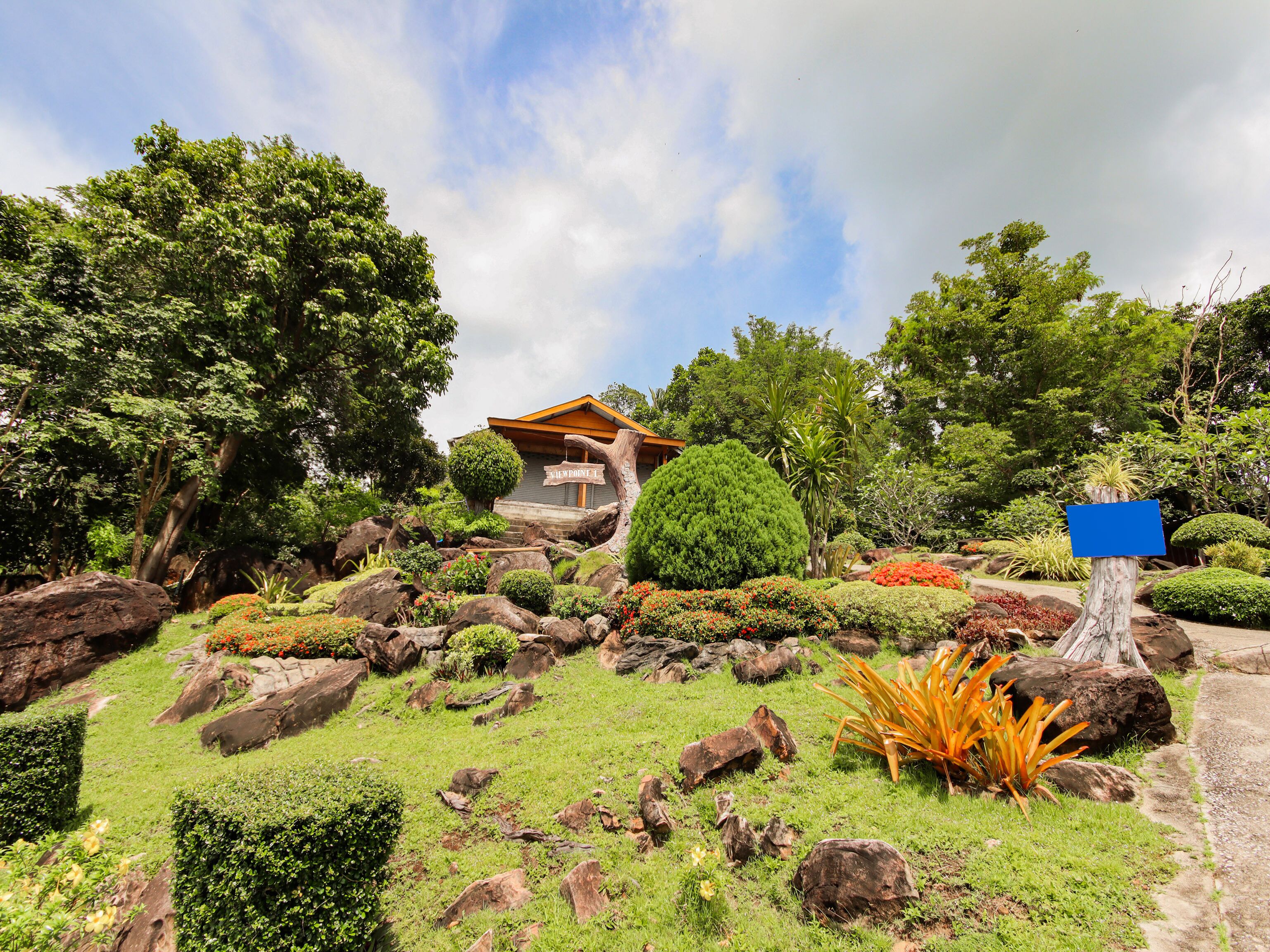 A house surrounded by lush greenery, with a clear sky above.