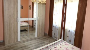 Ein Schlafzimmer mit einem Bett, einem Kleiderschrank, einem Spiegel und einer Pendelleuchte.