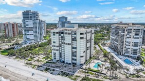 A high-rise hotel with multiple floors, a rooftop pool, and a beach view.
