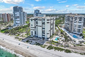 A high-rise hotel with multiple floors, a rooftop pool, and a beach view.