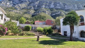 Zona residencial con casas, una palmera y una montaña al fondo.