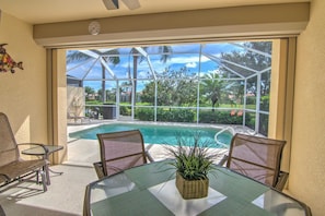 Eine sonnendurchflutete Terrasse mit Pool, Stühlen und einem Tisch mit Pflanze.