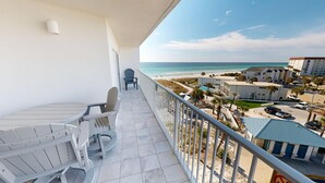 A balcony with a view of the beach and ocean, featuring a table and two chairs. - Seacrest 603 is a Gulf View 2 BR on Okaloosa Island by RedAwning (Fort Walton Beach)
