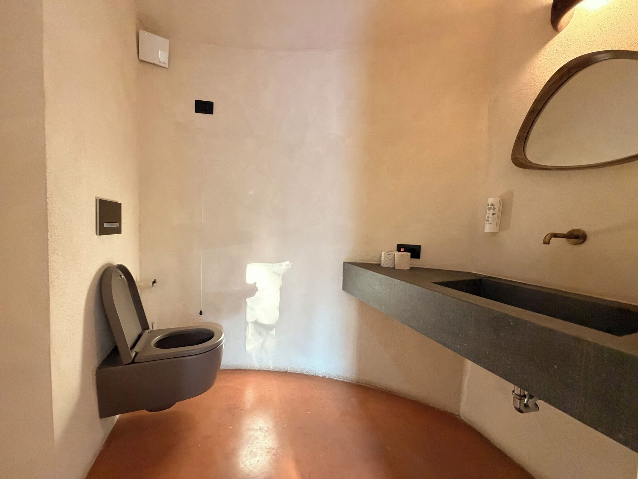 Un baño pequeño con inodoro, lavamanos y espejo.