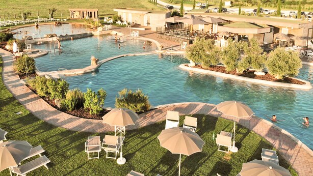 A resort with a large swimming pool, lounge chairs, and umbrellas. - Terme di Vulci Glamping & SPA (Canino)