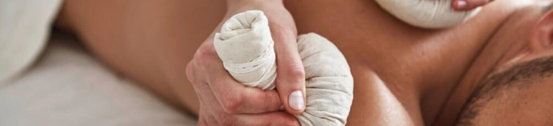 A close-up of a person's hands applying a white compress to another person's arm.