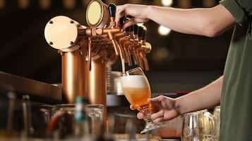 A person pouring beer from a tap into a glass.