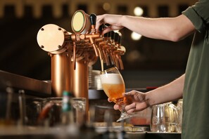 A person pouring beer from a tap into a glass. - The Gold Pan Motel (Eagle Nest)