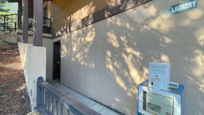 A laundry facility with a sign, a utility box, and a door.