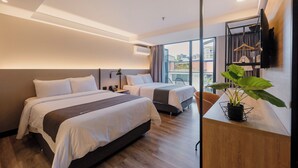A modern hotel room with two beds, a large window, a plant, and a TV mounted on the wall. - Lettera Hotel (Medellín)
