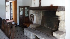 A room with a fireplace, a wooden cabinet, and a dining table with chairs. - House in Barbâtre on the Ile de Noirmoutier. Wifi La Cheminée 56 m2 -------- (Barbâtre)