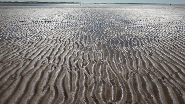 A sandy beach with rippled patterns, a clear sky, and a distant bridge. - House in Barbâtre on the Ile de Noirmoutier. Wifi La Cheminée 56 m2 -------- (Barbâtre)