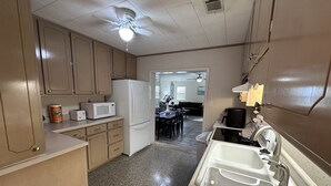 Cocina compacta con refrigerador, microondas y lavabo con grifo.