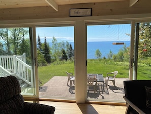 Una habitación con vista al mar, una terraza con mobiliario exterior y un letrero que dice 'lake HOUSE'.