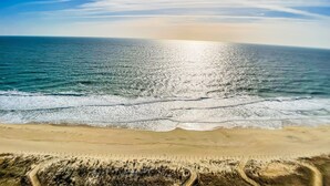 Ein Strand mit blauem Himmel und ruhigem Meer.