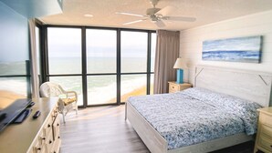 Ein Schlafzimmer mit Bett, Schreibtisch, Stuhl, Nachttisch, Lampe und einem Gemälde.