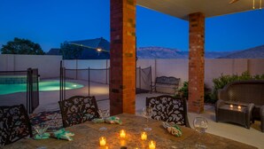 An outdoor patio with a pool, seating, and candles. - Hot tub with city views 
     -NO PARTIES ALLOWED- (Albuquerque)