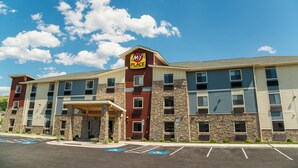 A multi-story hotel with a 'My Place' sign, parking spaces, and a covered entrance. - My Place Hotel - Midland (Midland)