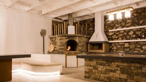 Una cocina moderna con chimenea de piedra, vigas de madera y una zona de bar integrada.